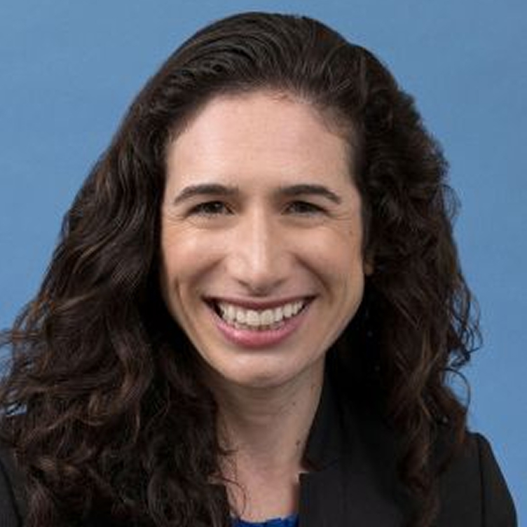 Portrait image of Jennifer Sumner smiling with blue background